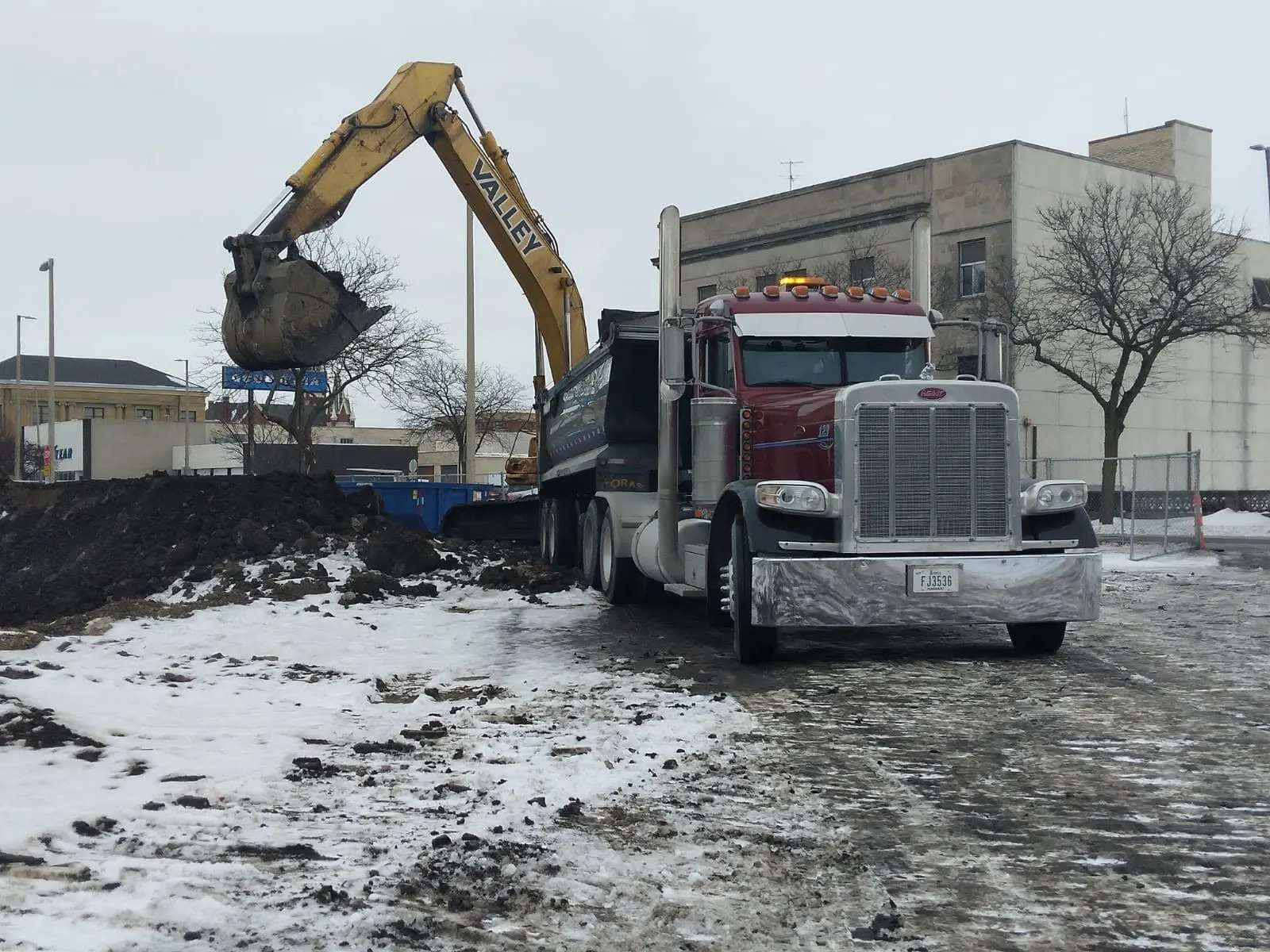 Dump truck loading beside an excavator